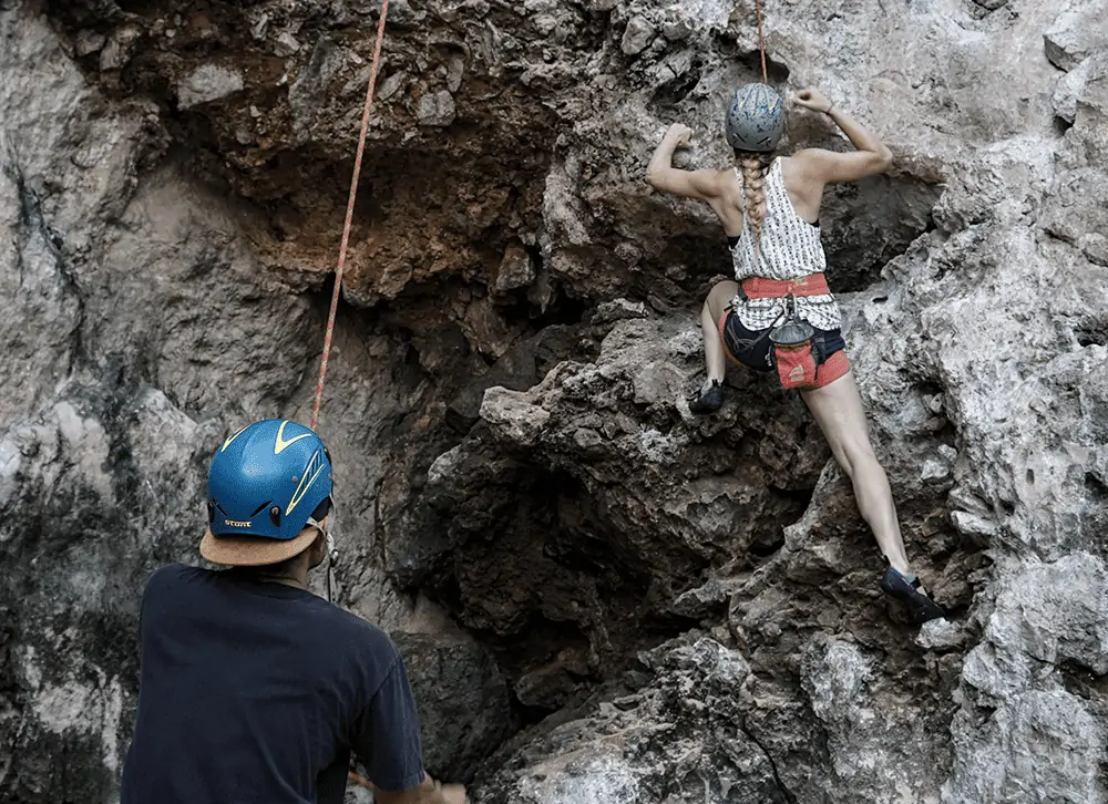 guy and girl rock climbing
