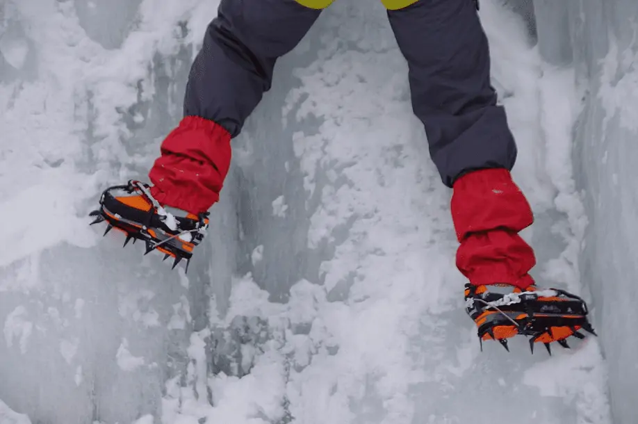 guy on ice ledge wearing crampons