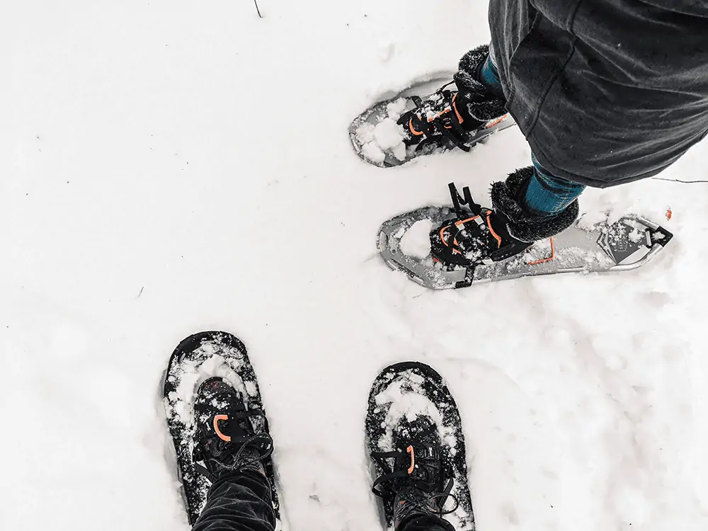 two hikers wearing snowshoes